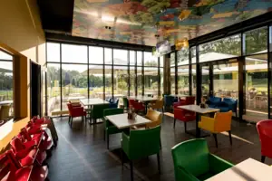 Ein Restaurant mit bunten Stühlen und Tischen.