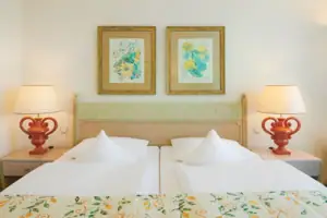 Ein Bett mit zwei Lampen und zwei Bildern an der Wand.