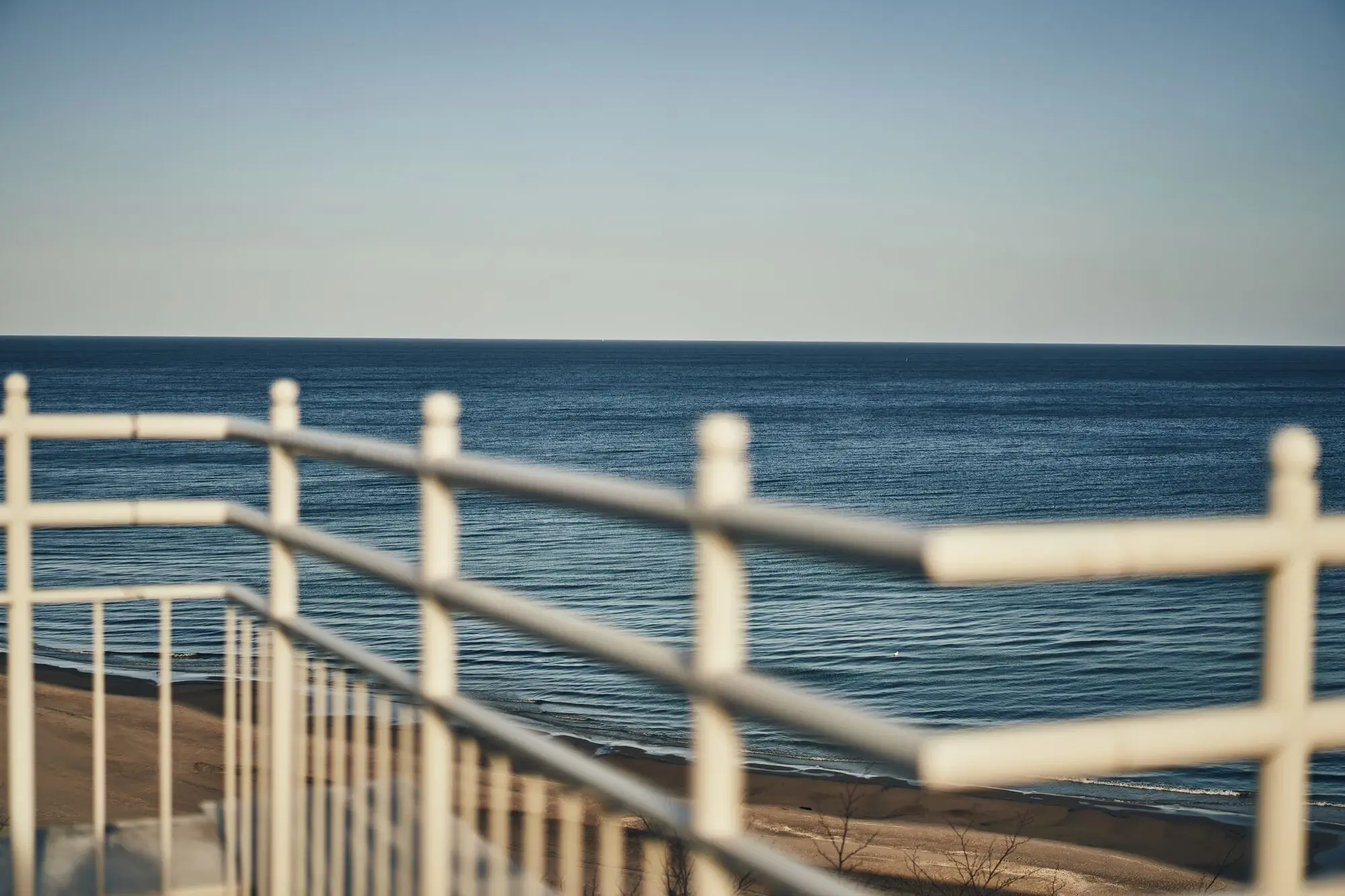 Weißes Geländer mit Blick auf das Meer.