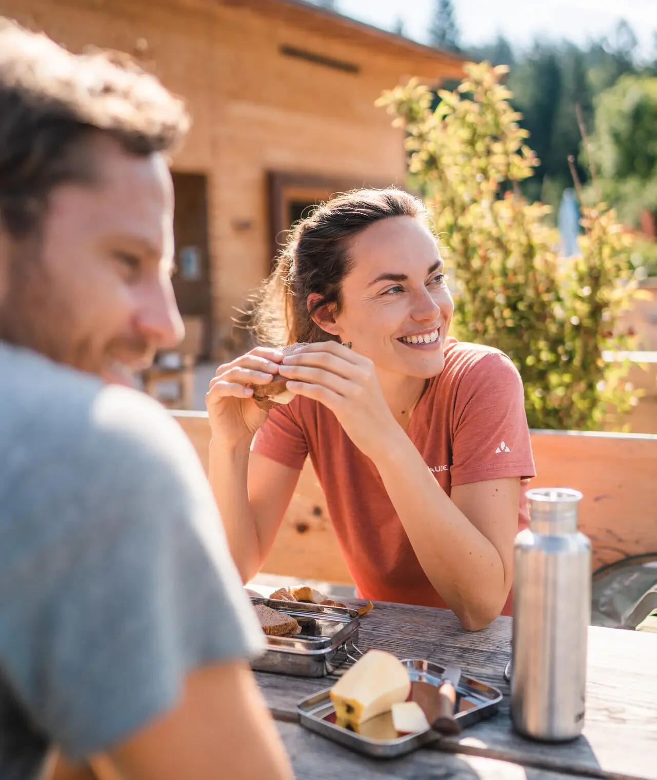 Ein Mann und eine Frau sitzen draußen an einem Tisch beim Essen.