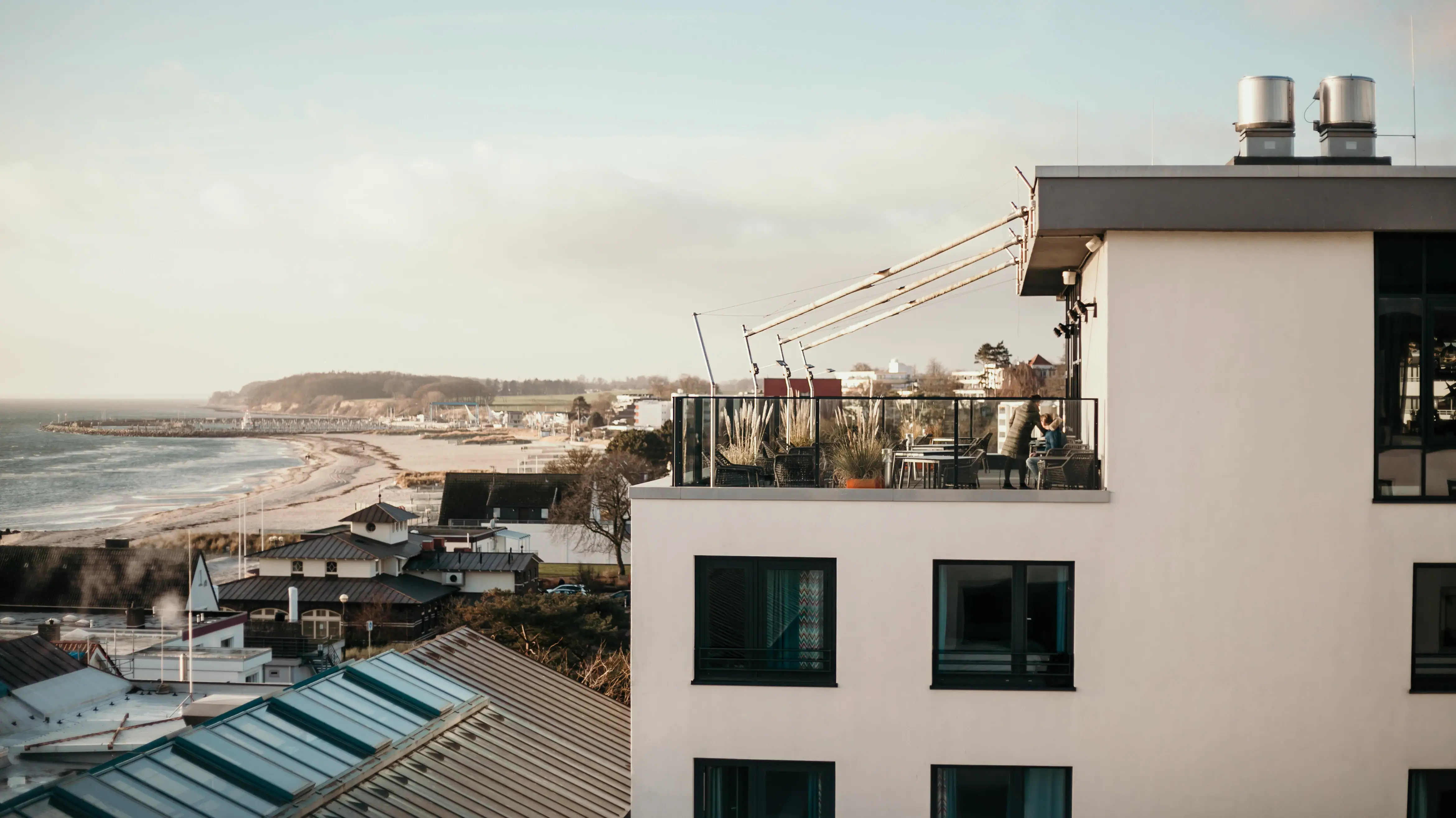 Ein Gebäude mit einem Balkon, der auf ein Gewässer blickt.