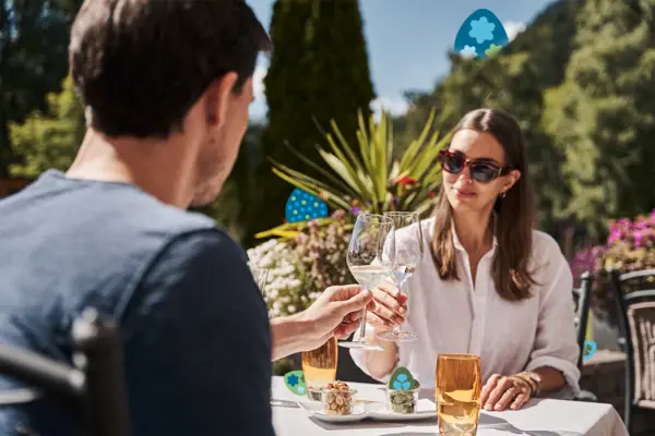 Ein Mann und eine Frau halten Weingläser an einem Tisch.