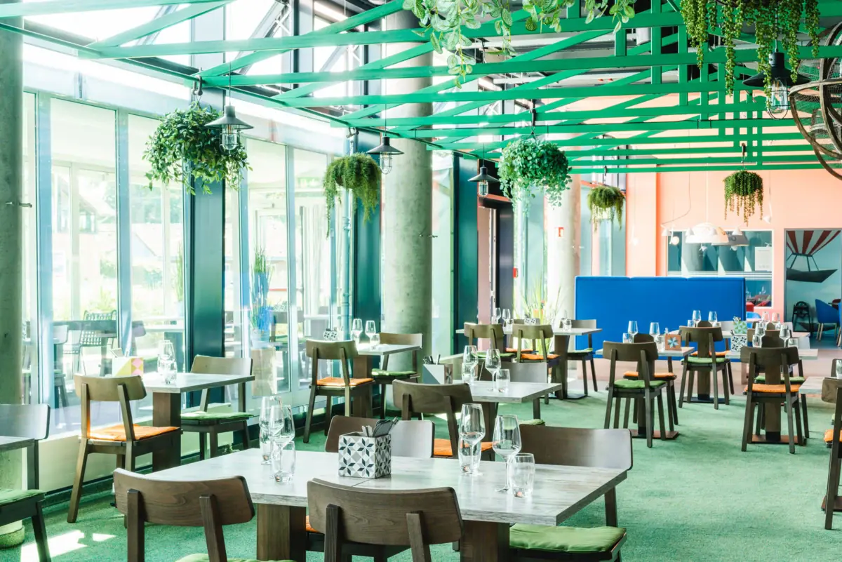 JEDERMANNS Restaurant Travemünde Ein Raum mit Tischen und Stühlen.