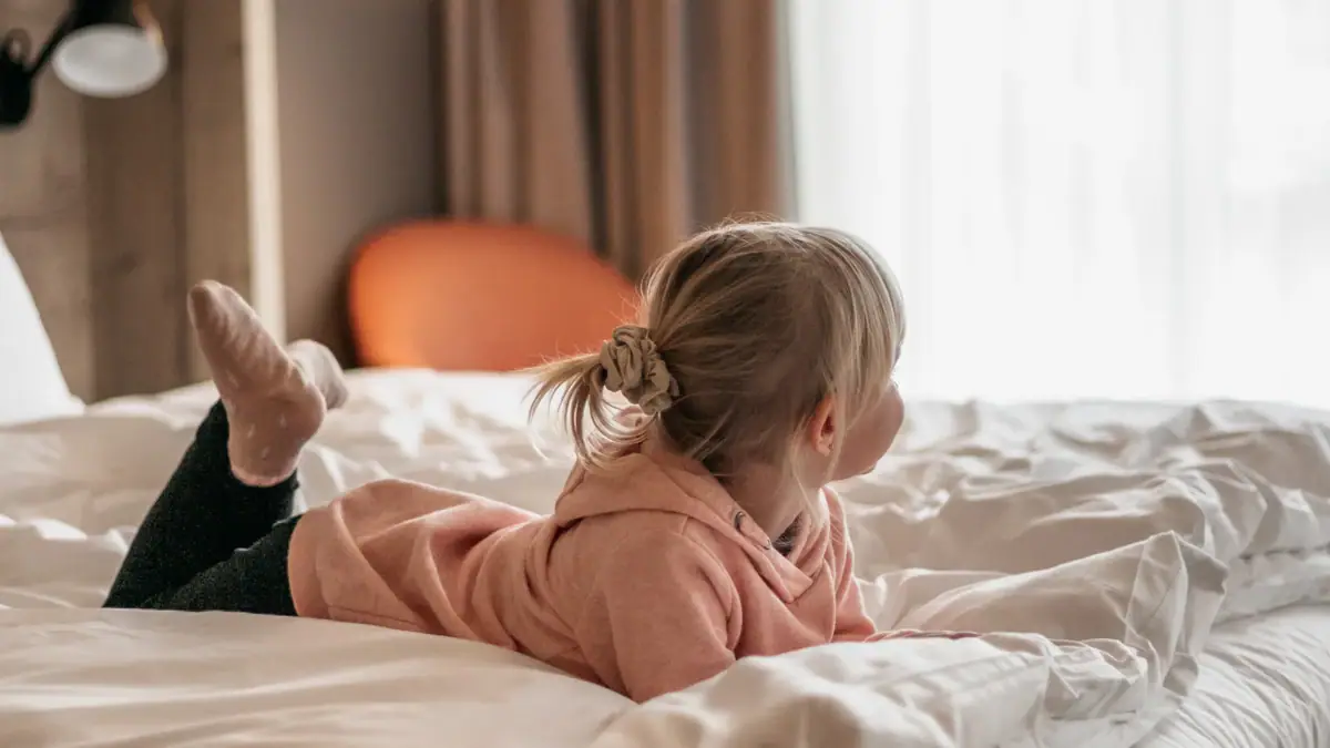 Ein Kind liegt auf einem Bett.