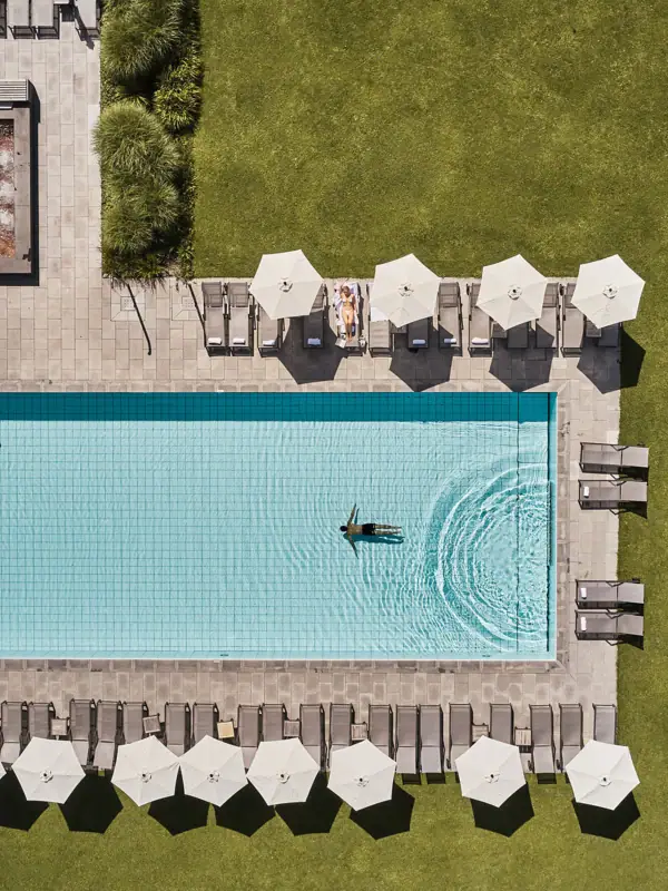 Pool Ein Swimmingpool mit Sonnenschirmen und Rasen.