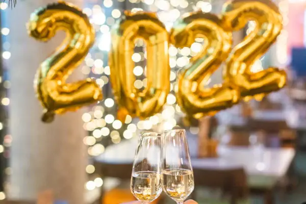 Zwei Personen stoßen mit Champagnergläsern an.