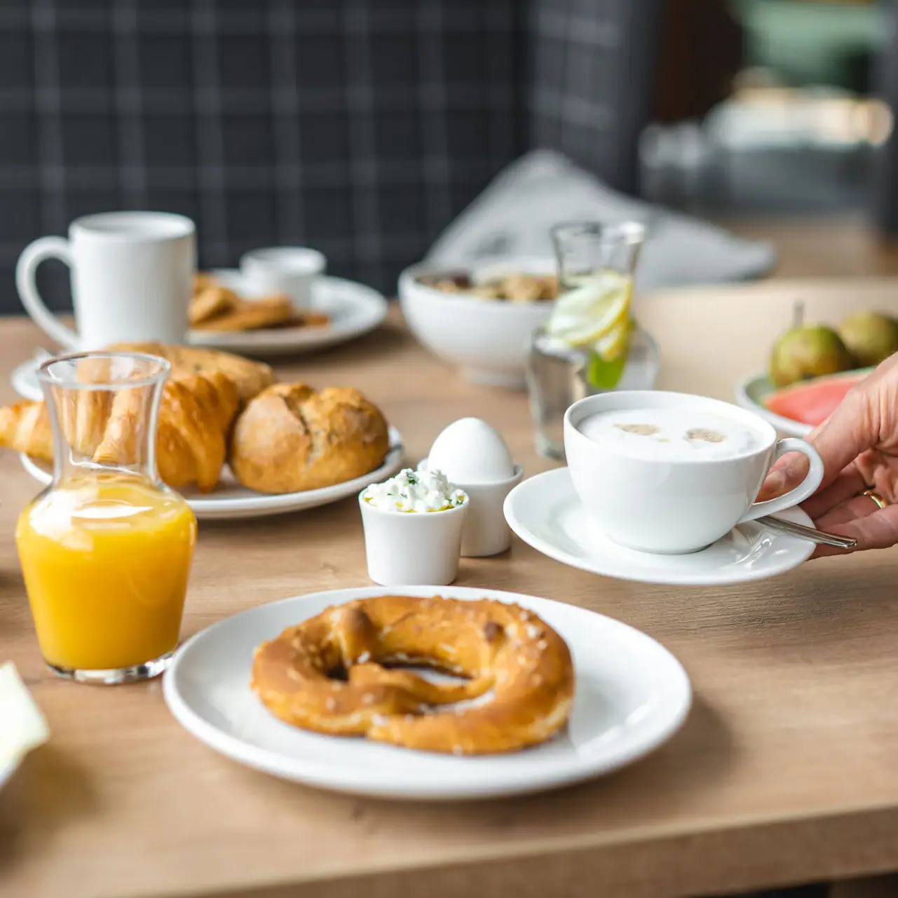 Frühstück Ein Tisch mit verschiedenen Speisen und Getränken, darunter Teller, Tassen und Saft.
