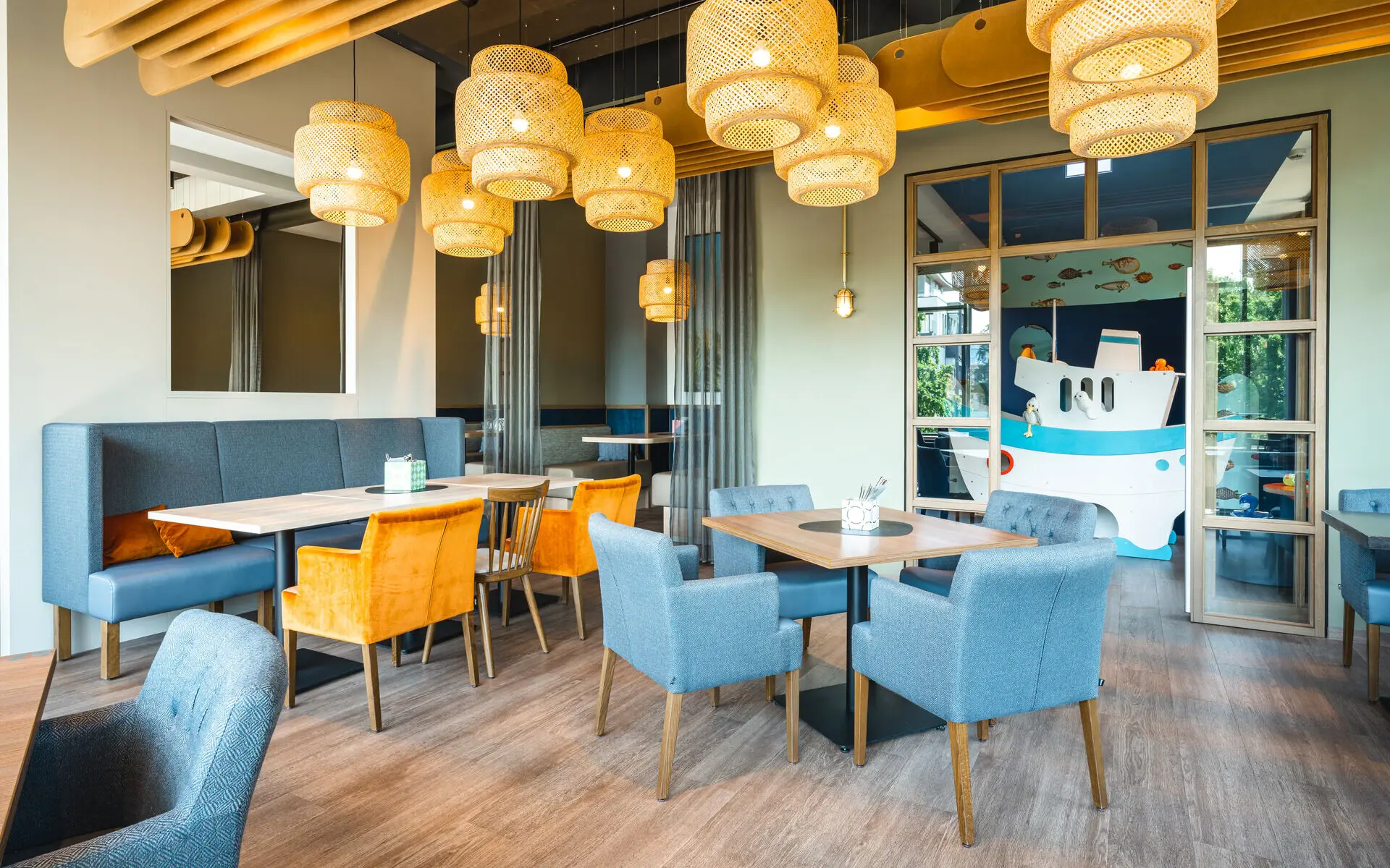 Familienbereich im Restaurant Bunte Stühle und Tische in einem Raum.