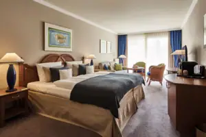 Familienzimmer Hotelzimmer mit einem Bett und Stühlen.