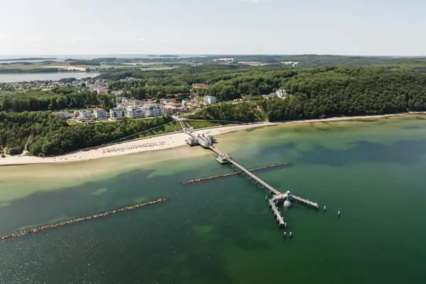 Ein Steg an einem Strand mit Blick auf das Wasser und den Himmel.