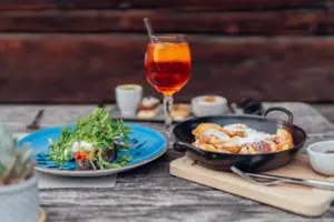 Ein Teller mit Essen und ein Getränk auf einem Tisch.