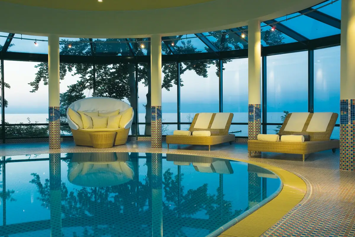 Ein Pool mit Stühlen und einem großen Fenster.