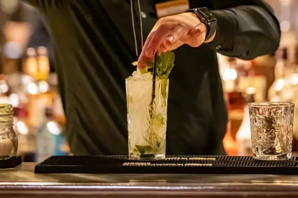 Ein Mann hält eine Zange an ein Getränk.