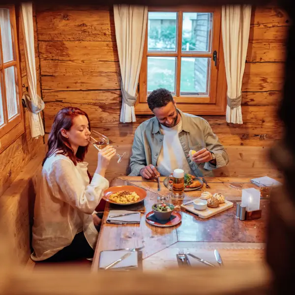 Ein Mann und eine Frau sitzen an einem Tisch mit Essen und Getränken.