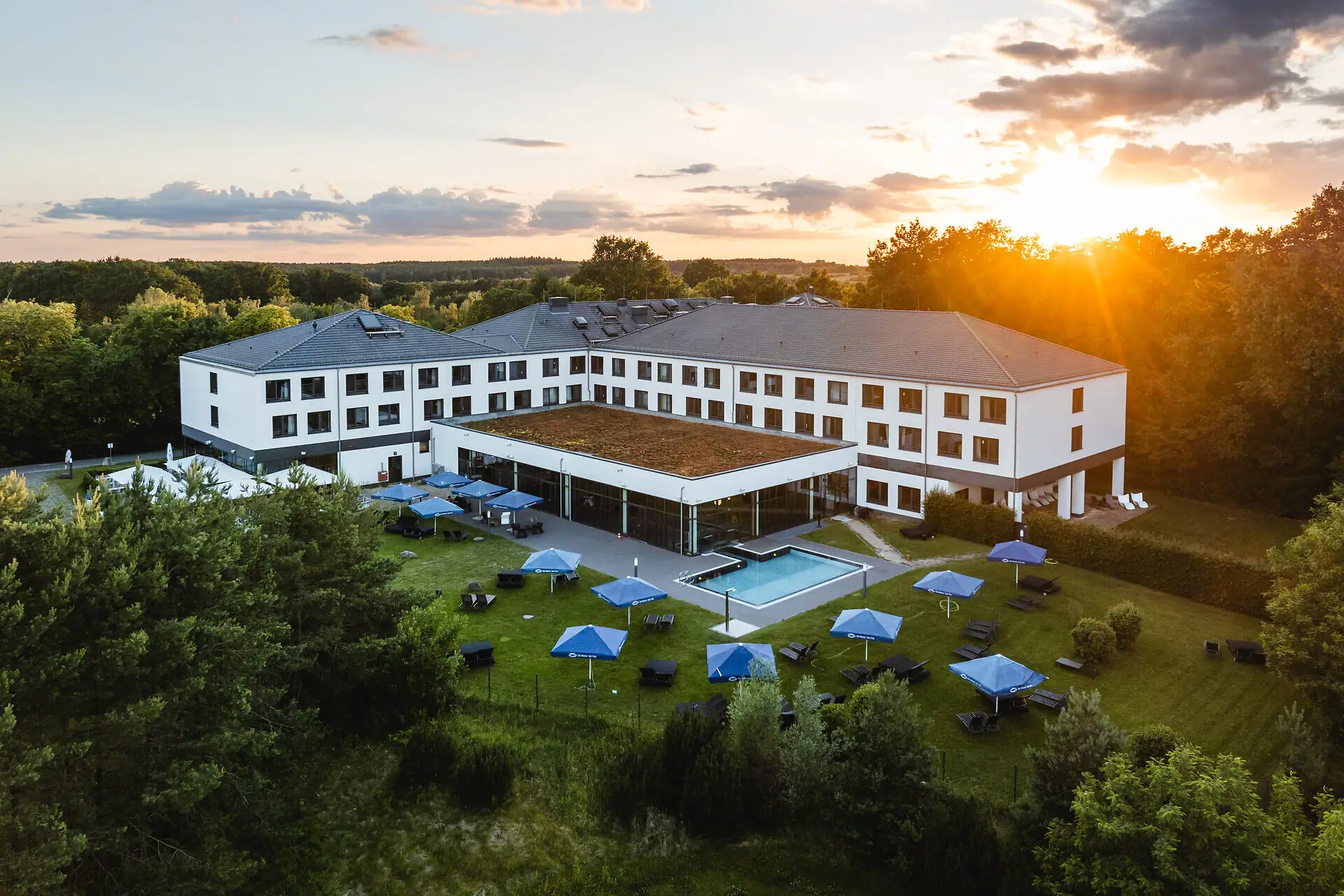 Gebäude mit einem Pool und Sonnenschirmen in der Mitte.