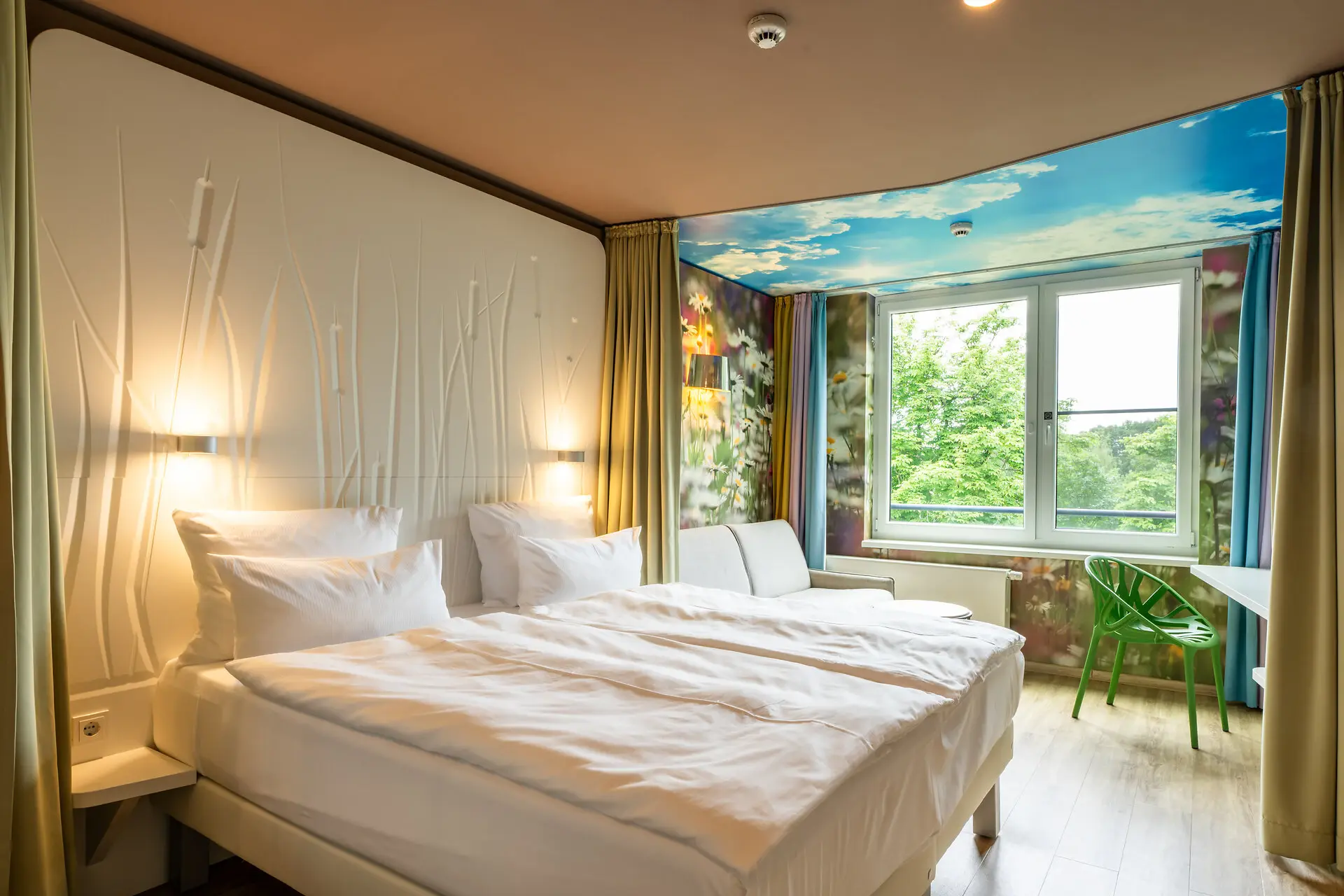 Interior view of a bedroom featuring two beds with pillows, linens, and a window with curtains.