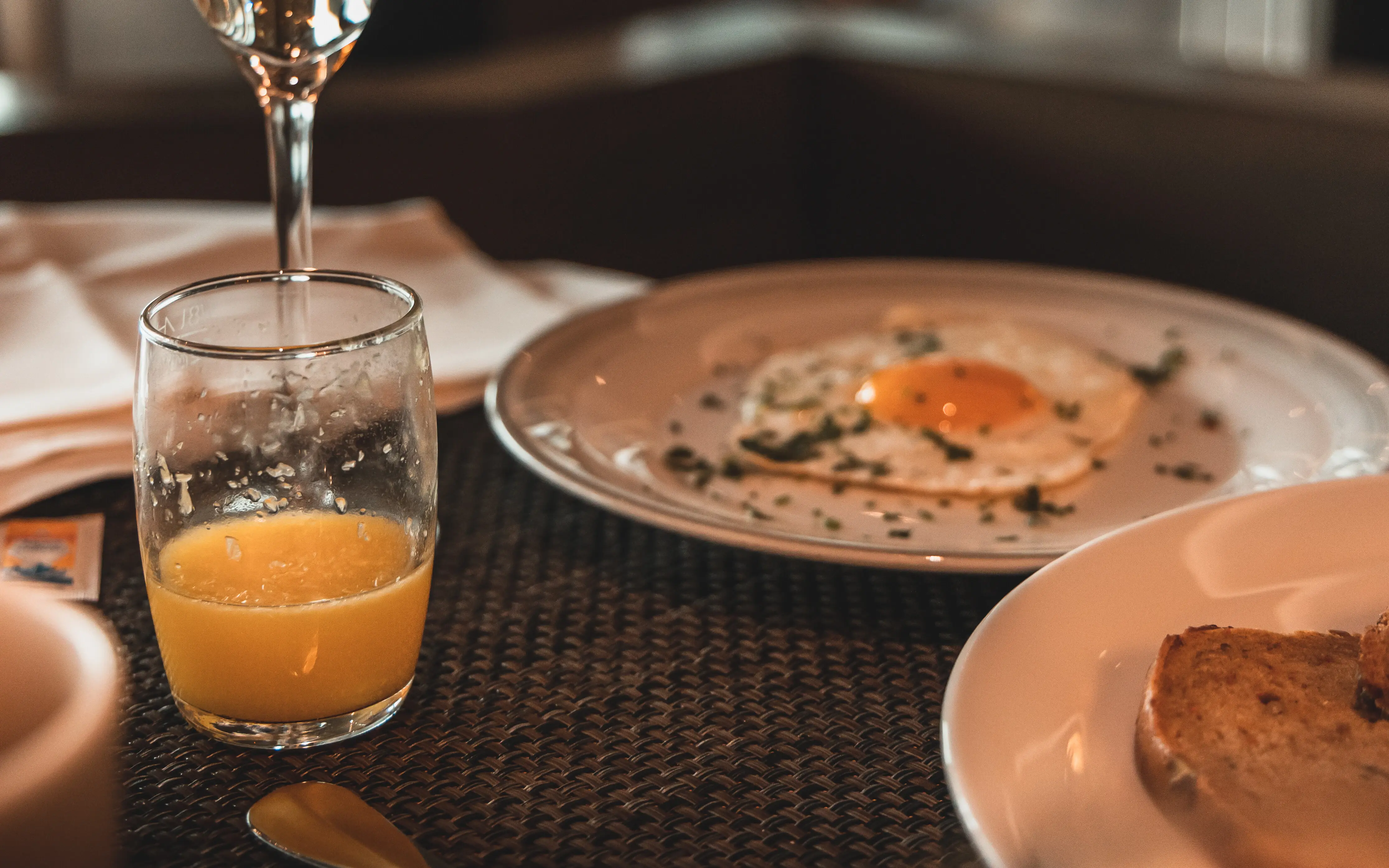 Ein Glas Champagner neben Tellern mit Essen.