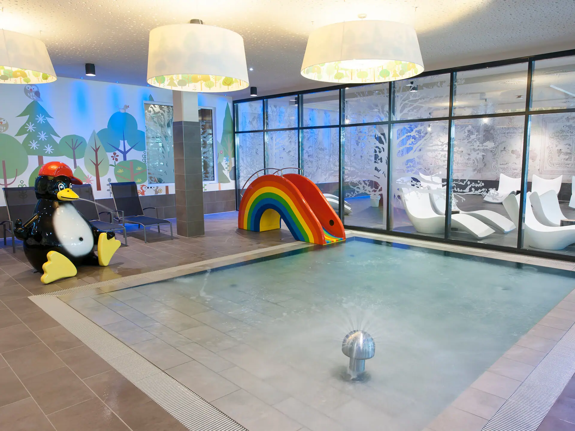 Kinderpool im aja Bad Saarow Ein Pool mit einer Rutsche und einem Pinguin.