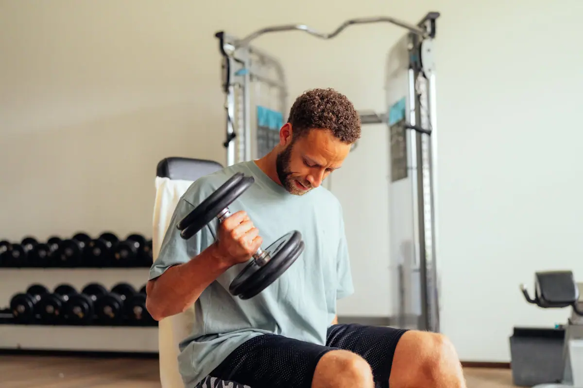 Hanteltraining Ein Mann hebt Gewichte in einem Fitnessstudio.
