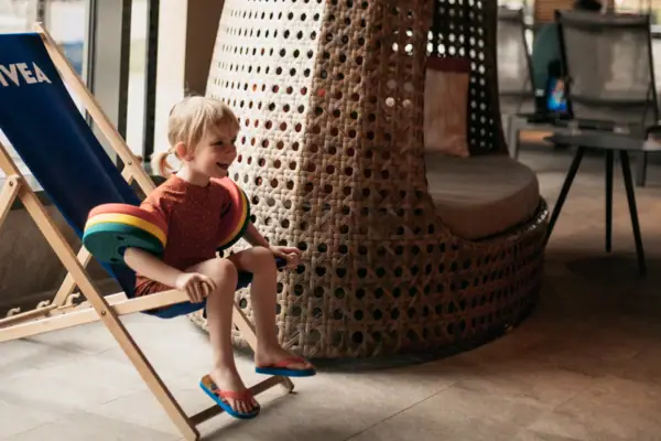 Ein Kind sitzt auf einem Stuhl.