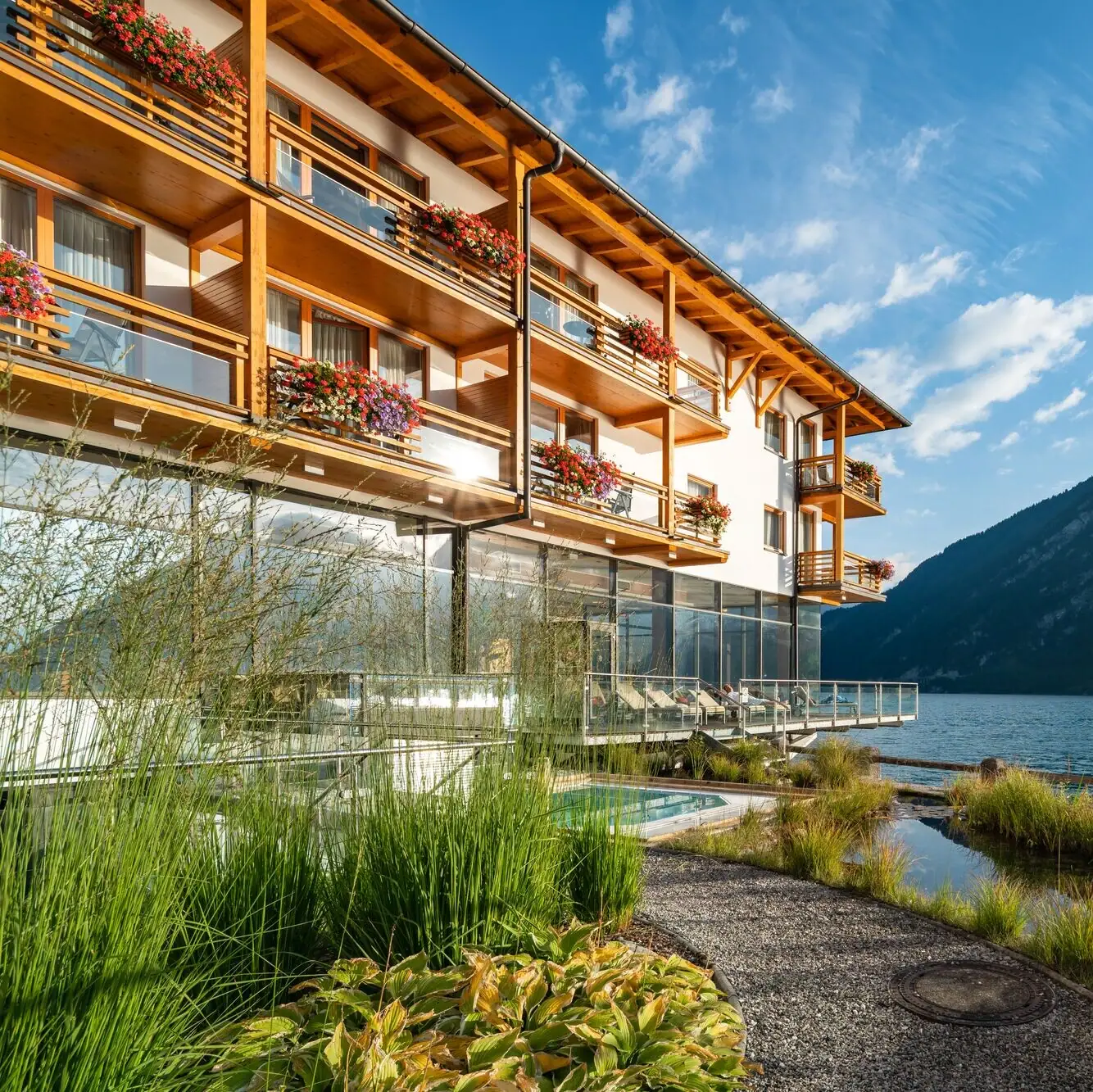 Ein Gebäude mit einem See und Bergen im Hintergrund.