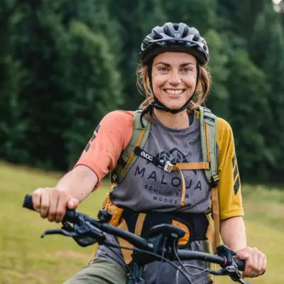 Radfahren Eine Frau fährt Fahrrad und lächelt in die Kamera.