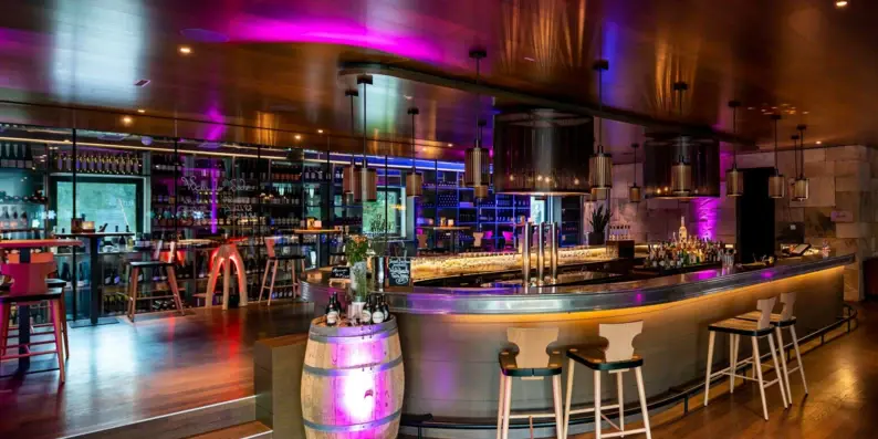 Bar with a barrel and stools in the interior of a building.