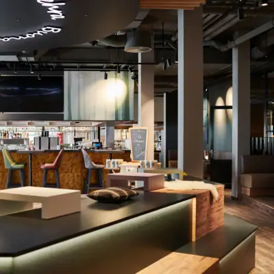 Barbereich im aja Ruhpolding  Eine Bar mit Fernseher und Barhockern.