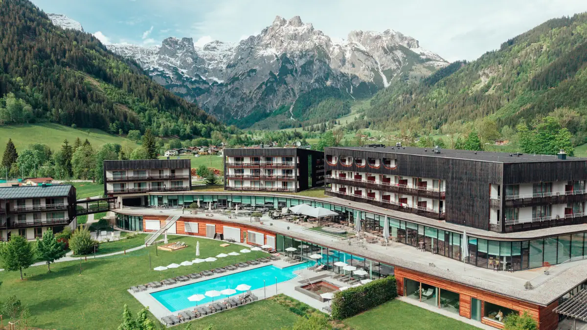 Hotel mit Swimmingpool und Bergen im Hintergrund