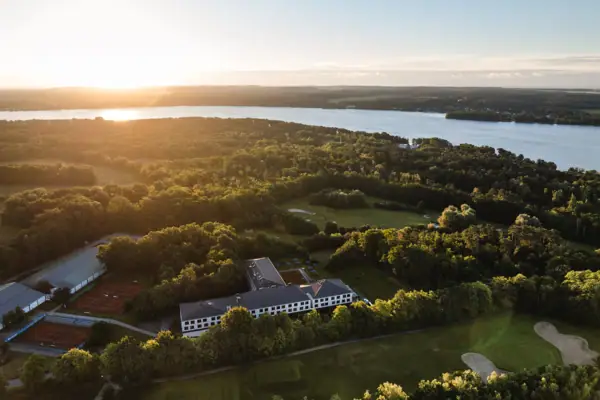 Ein großes Gewässer mit einem Gebäude und Bäumen.