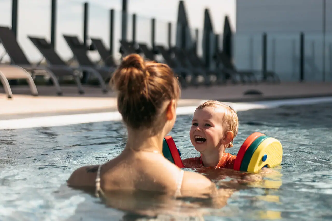 Eine Frau und ein Kind im Schwimmbecken.
