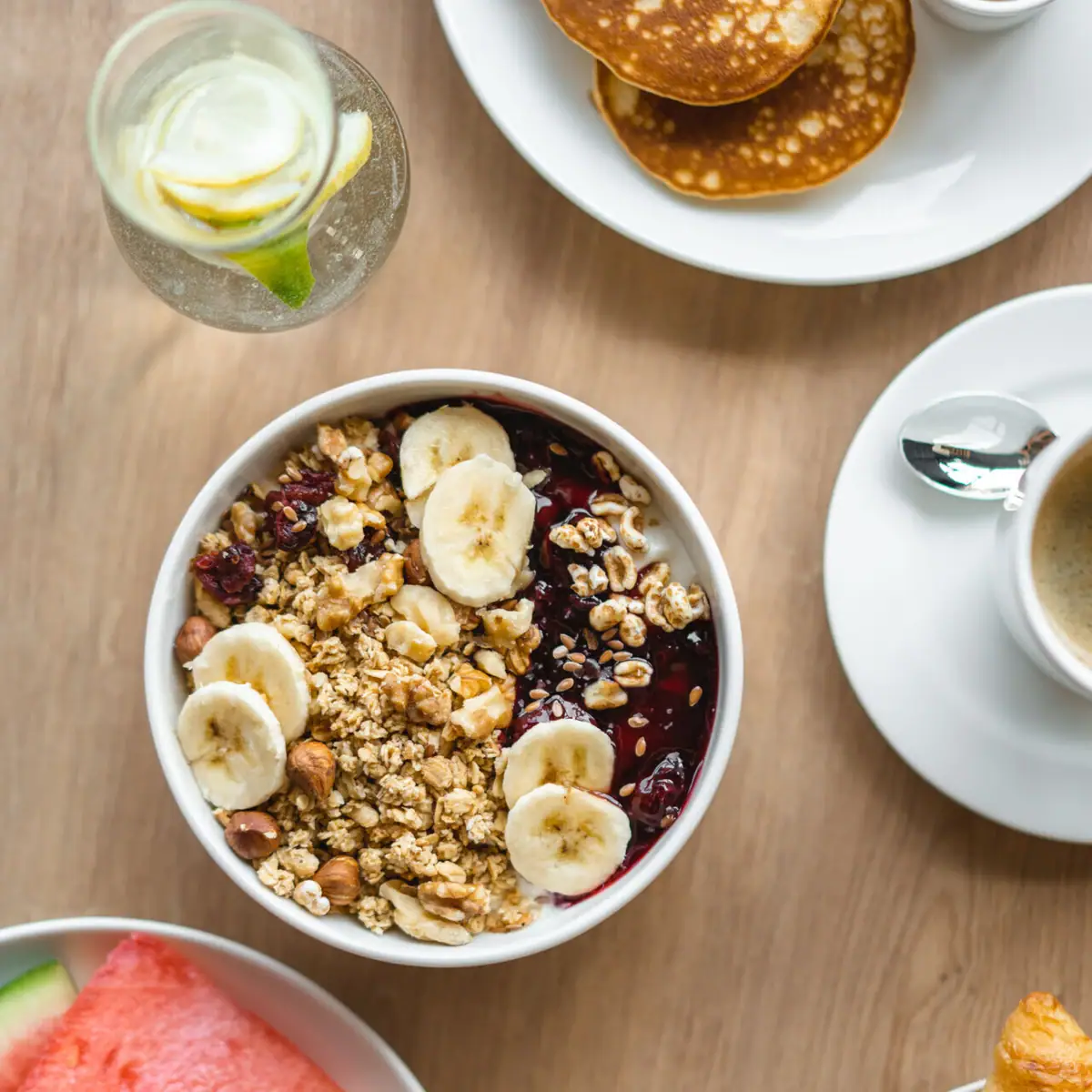 Frühstück Eine Schüssel mit Müsli und eine Tasse Kaffee.