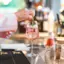 Eine Person legt ein Blatt auf ein Getränk im Glas.
