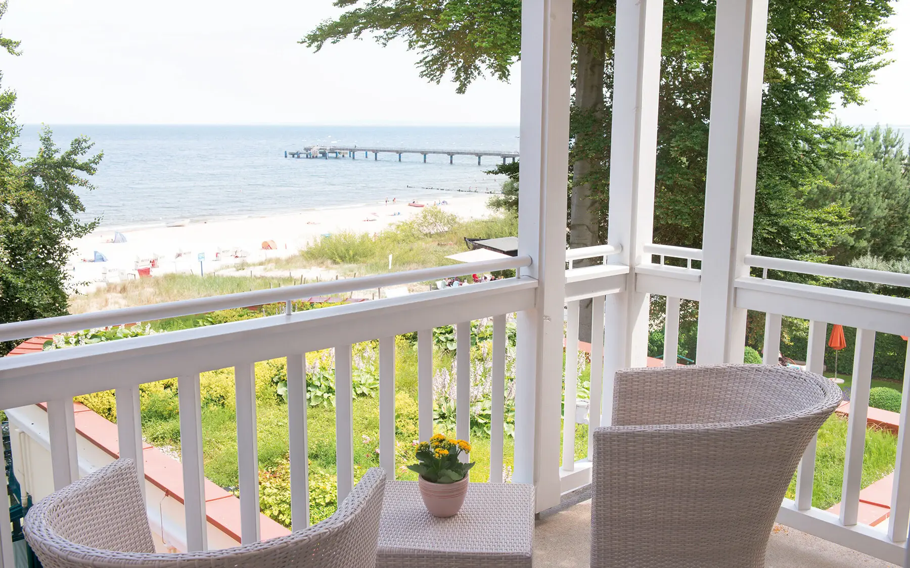 Einladende Terrasse mit Stühlen und Blick auf den Strand.