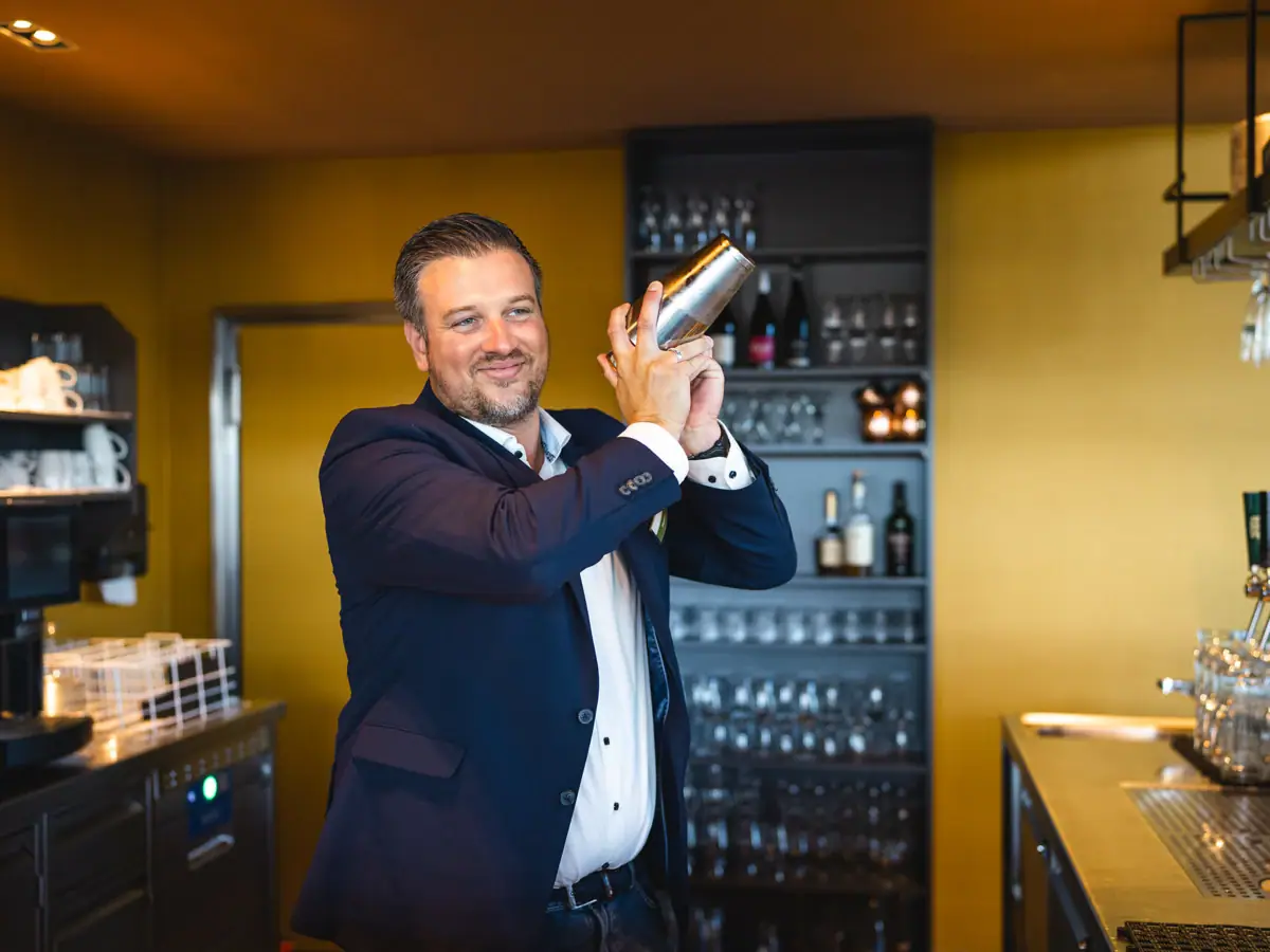 Ein Mann hält einen Shaker.