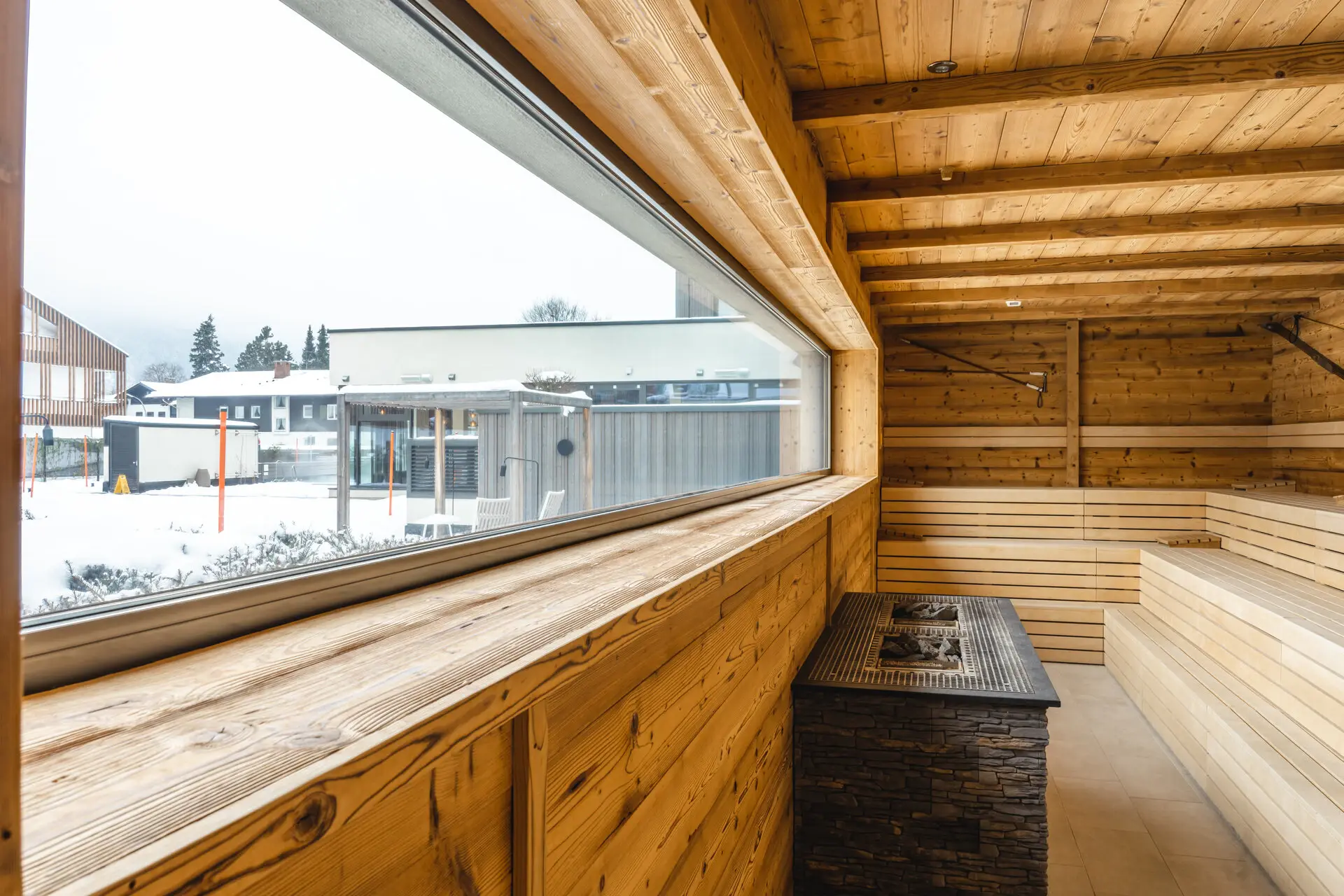 Eine Sauna mit großem Fenster und einem Kamin.