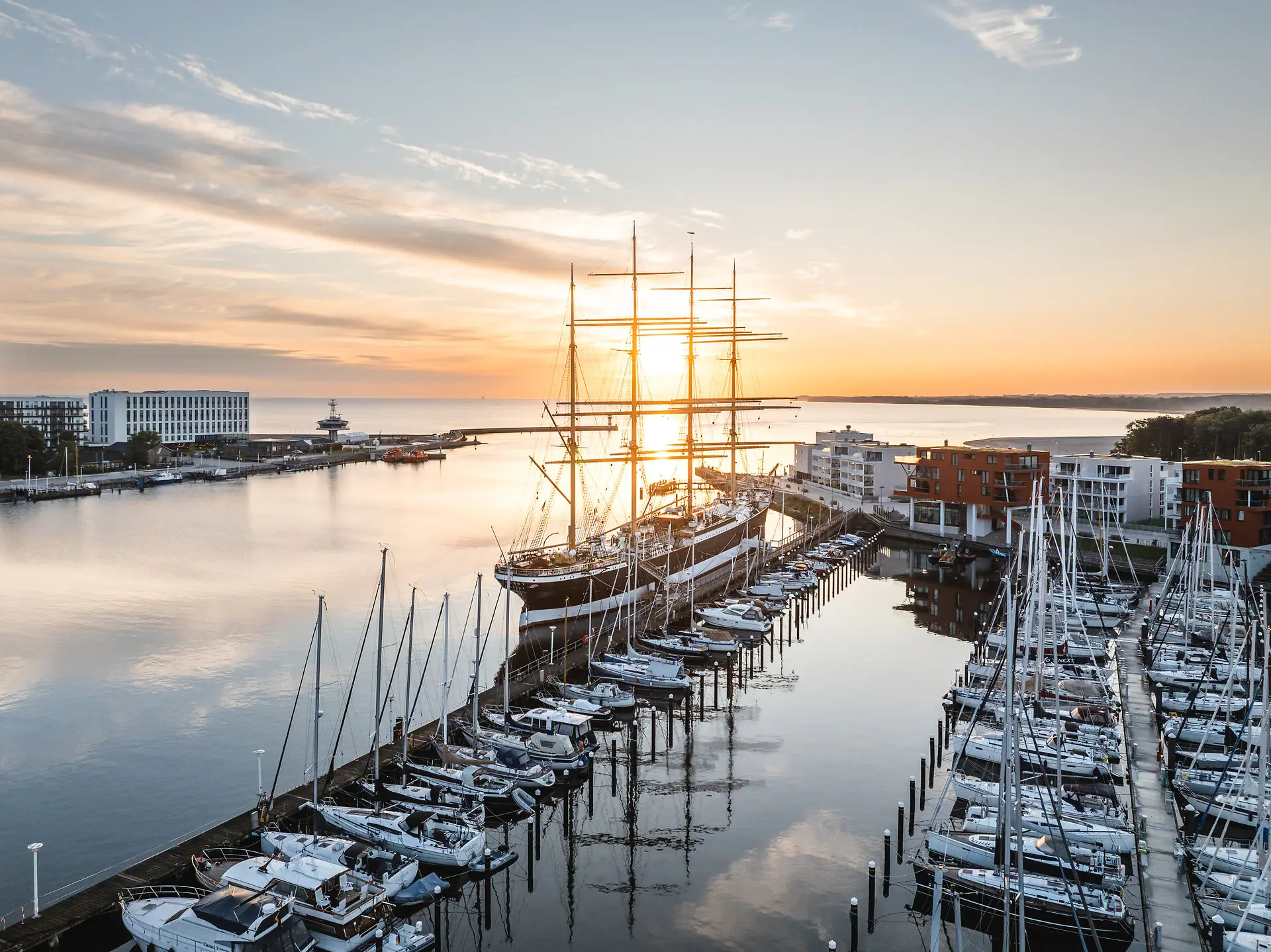Travemünde Ein großes Schiff im Hafen bei Sonnenaufgang.