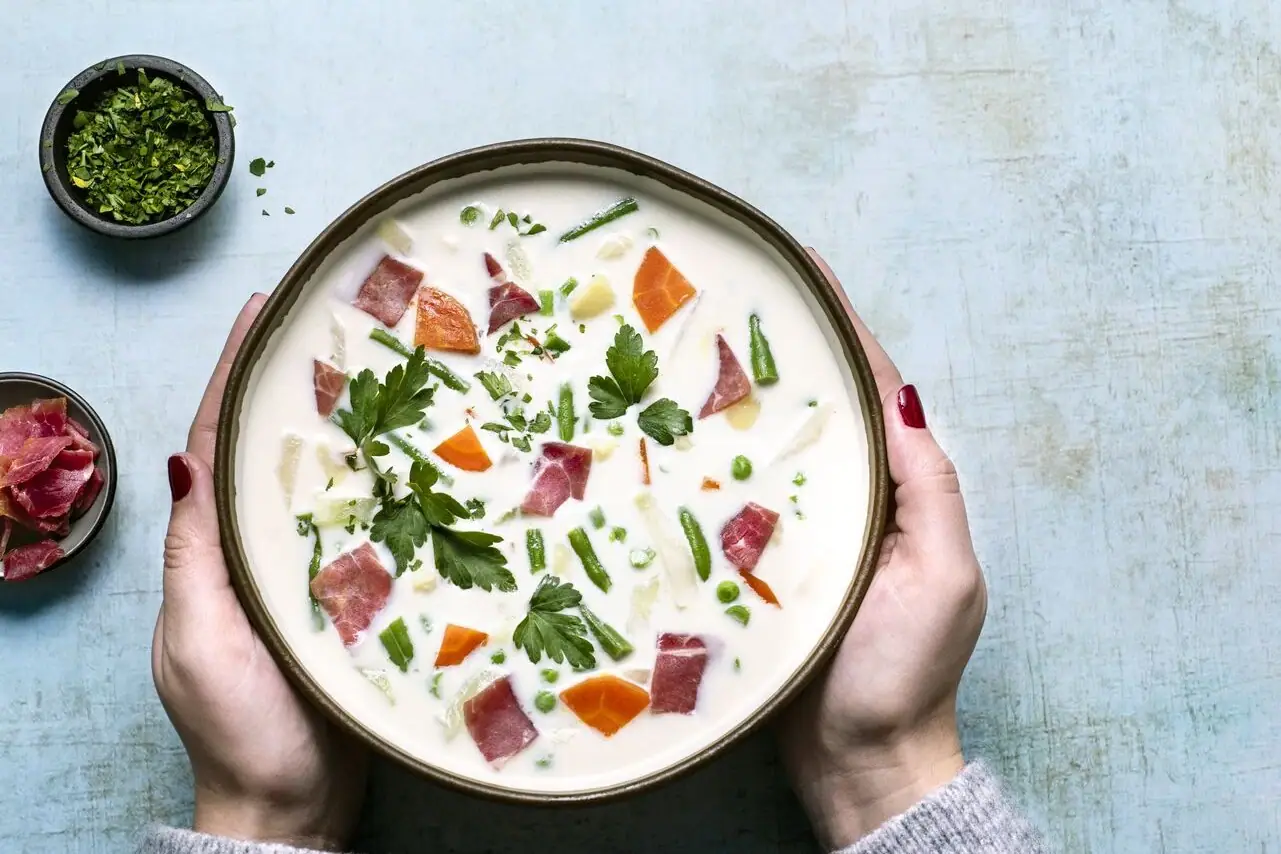 Suppe Eine Schüssel Suppe mit Gemüse und Fleisch.