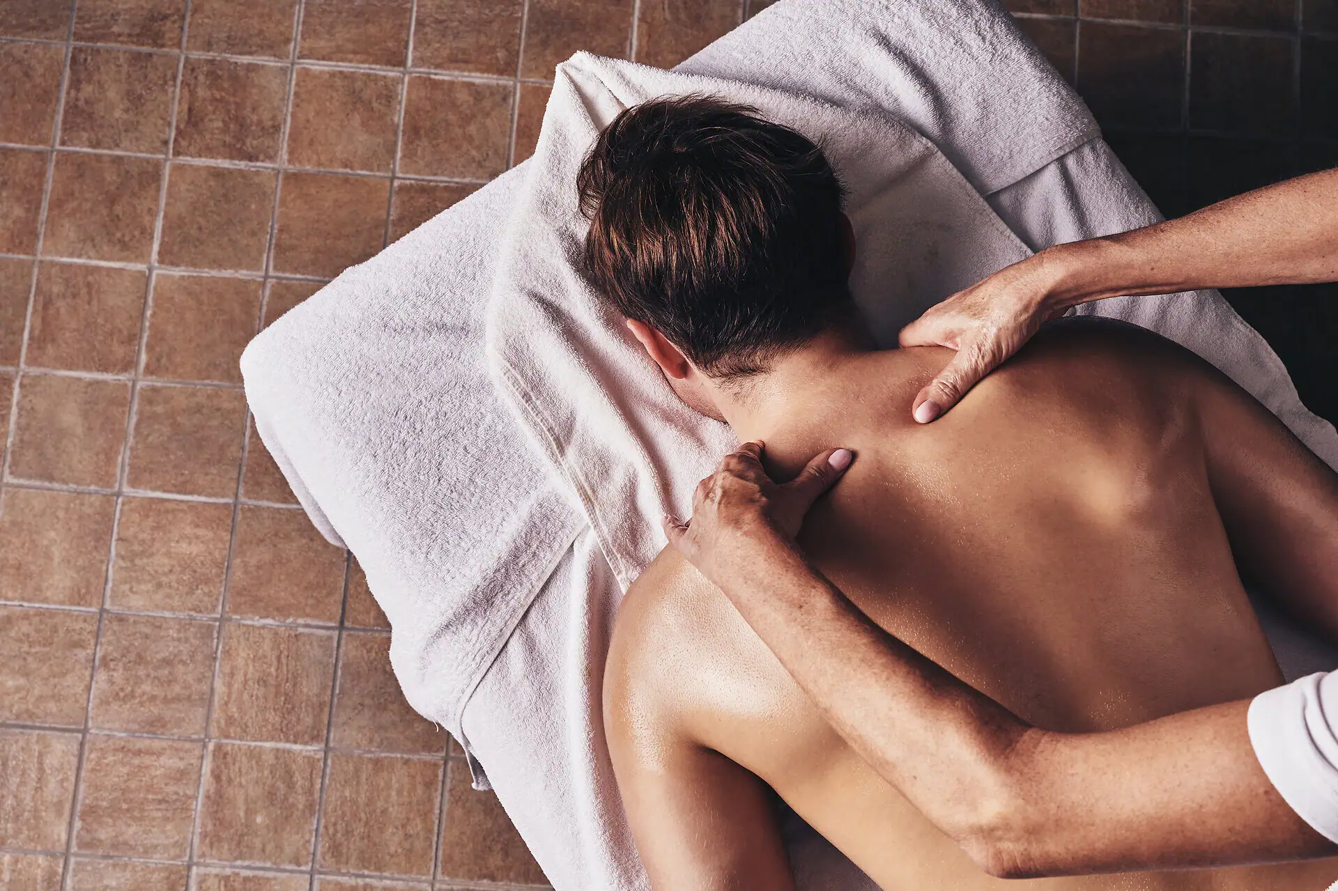 Eine Person liegt auf einem Massagetisch.