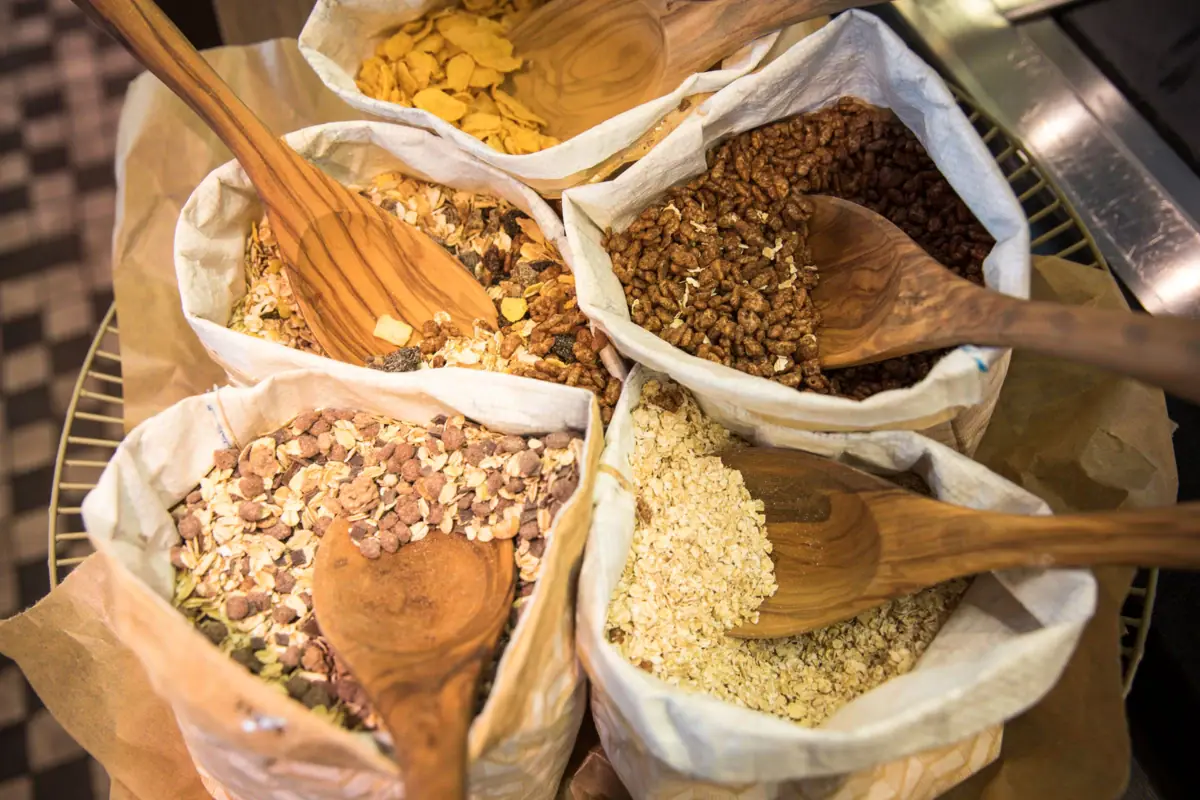 Frühstück im JEDERMANNS Eine Gruppe von Beuteln mit Müsli und Holzlöffeln.