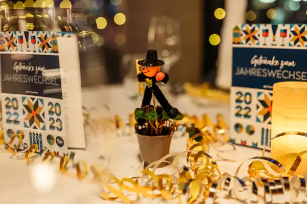 Dekoration bestehende aus einem Schornsteinfeger, Luftschlangen und weißer Tischdecke im Restaurant