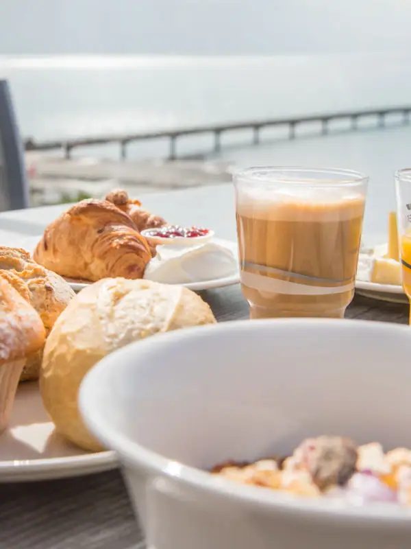 Ein Tisch mit verschiedenen Speisen und Getränken, darunter Gebäck und Tassen.