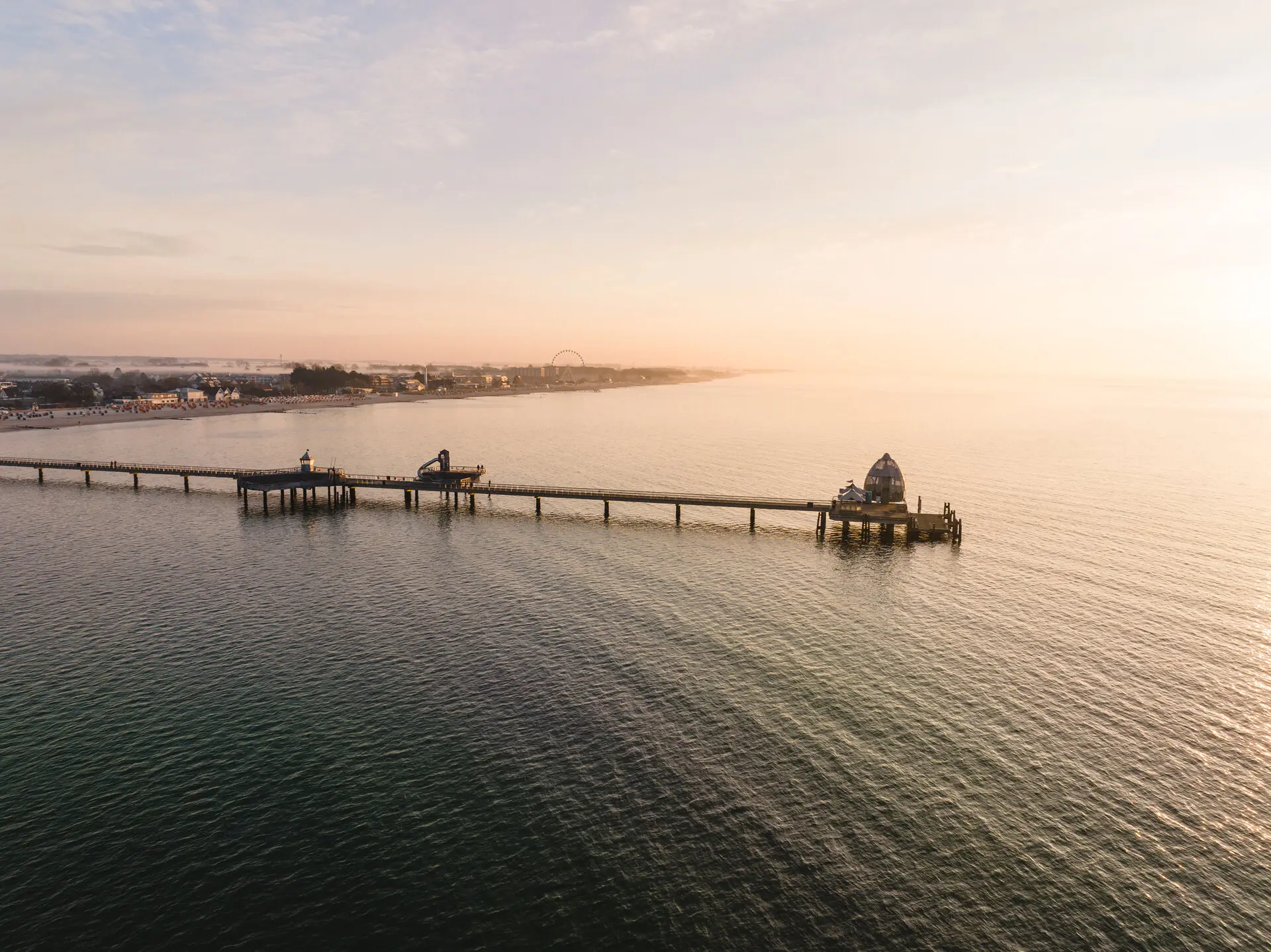 Ein Pier, der ins Wasser ragt, unter einem bewölkten Himmel.