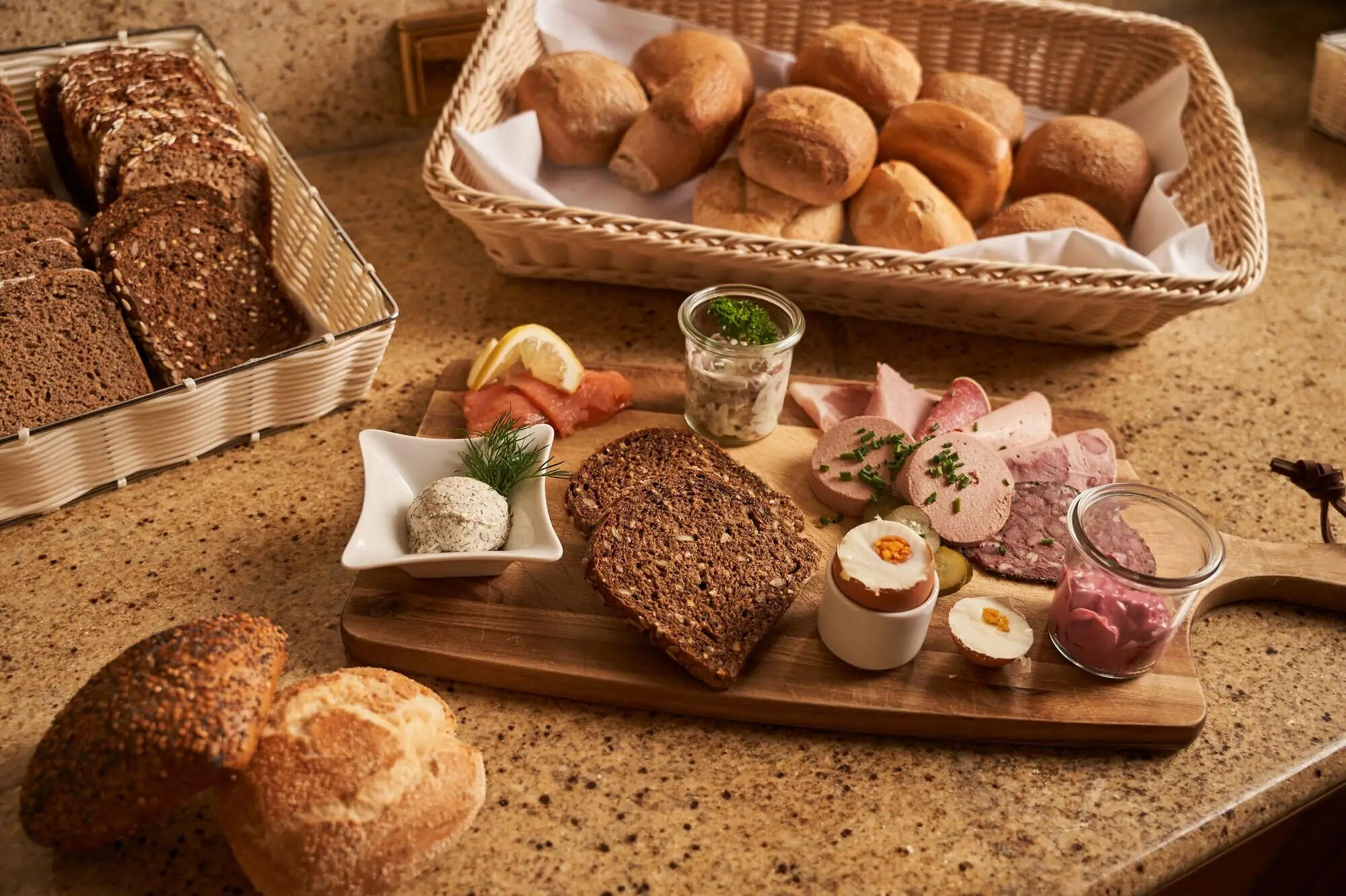 Aufschnitt Frühstück Holzbrett mit verschiedenen Backwaren darauf.