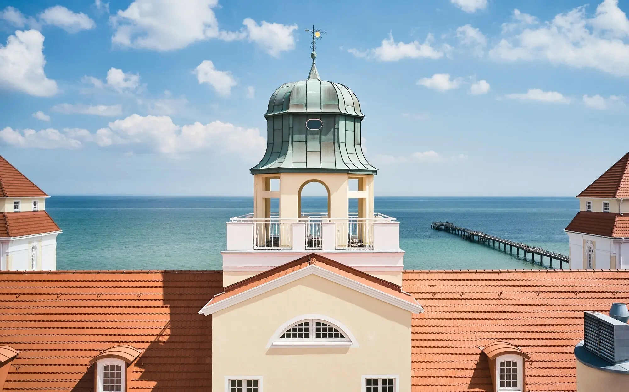 Blick auf ein Gebäude mit einem Turm und einem Pier im Hintergrund.