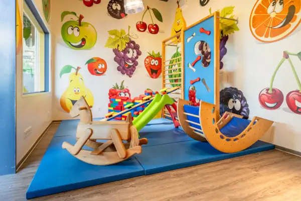 Spielbereich in einem Raum mit Kinderkunst an der Wand.