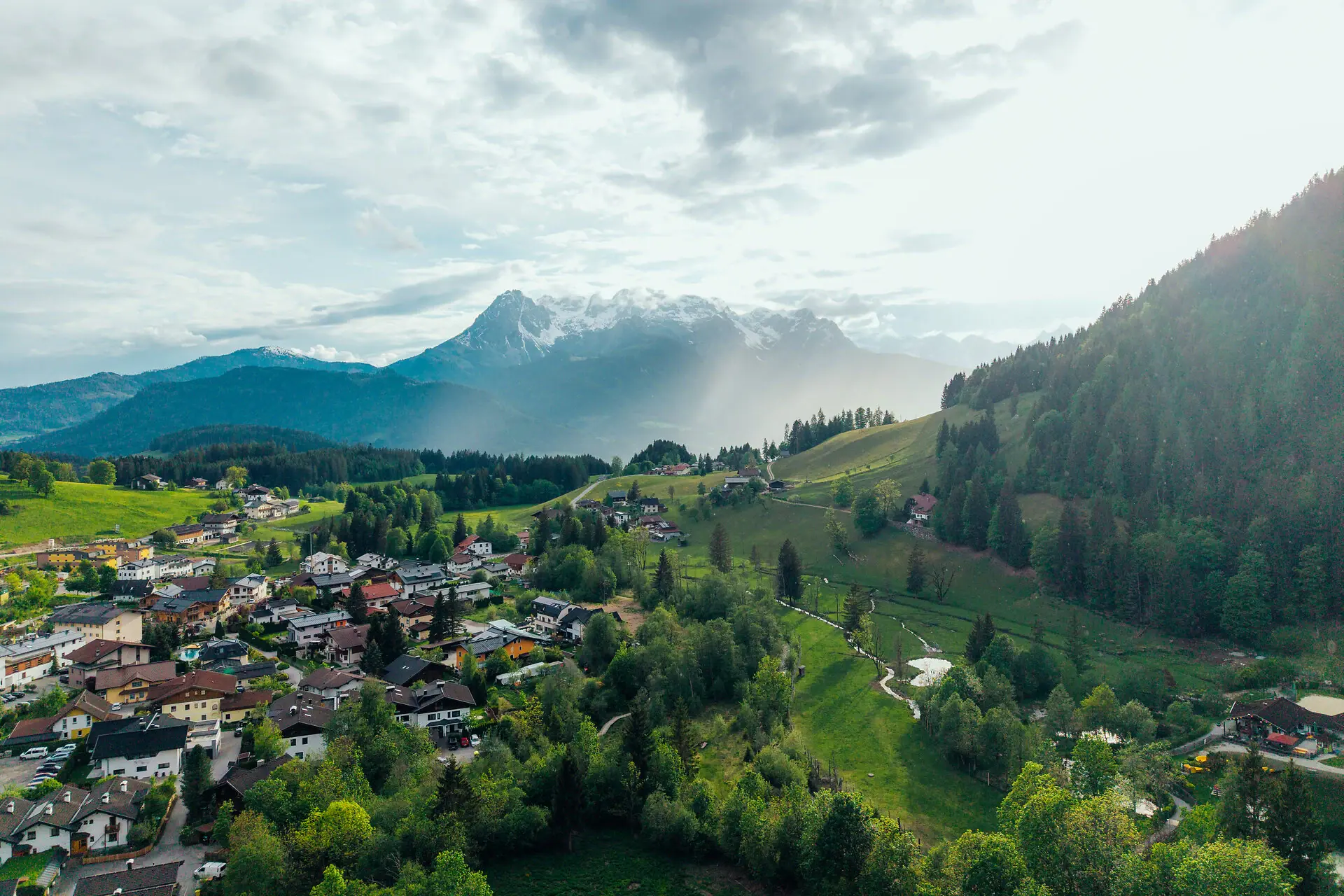 Eine Stadt in einem Tal mit Bäumen und Bergen.