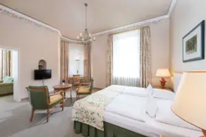 Ein Zimmer mit einem Bett und Stühlen.