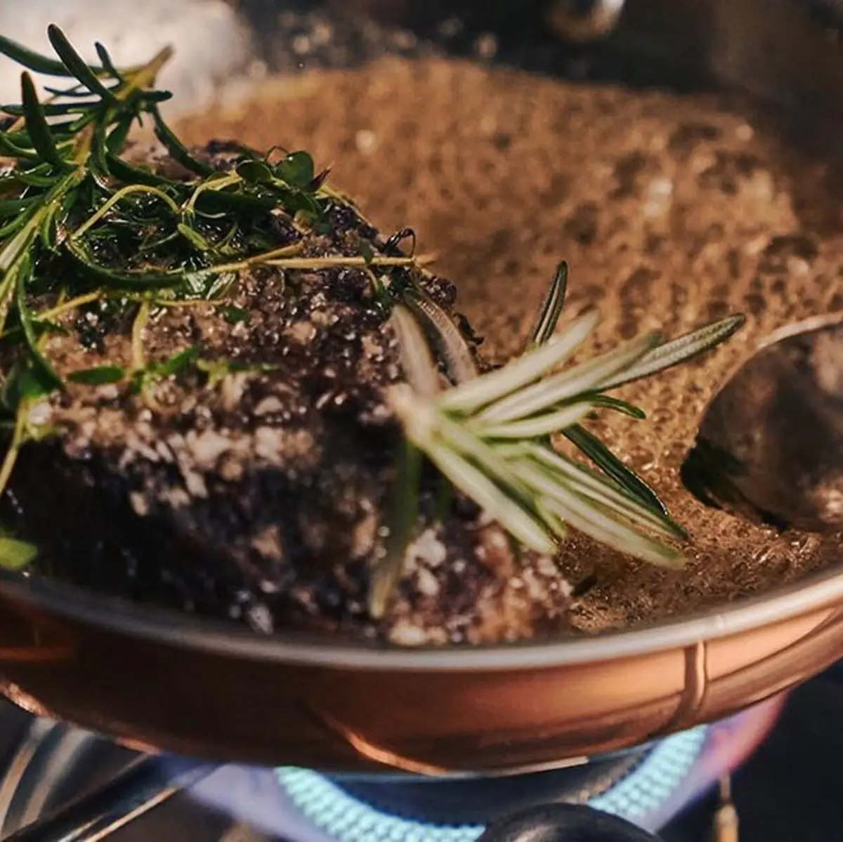 Ein Topf mit einem Stück Fleisch und einem Löffel.