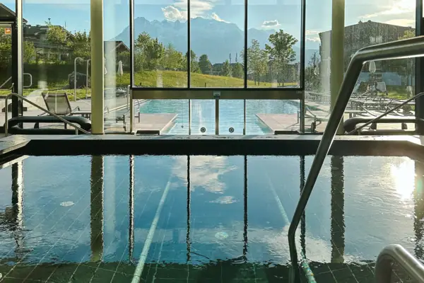 Innenpool Ein Pool mit Treppen und Geländern in einem Gebäude.